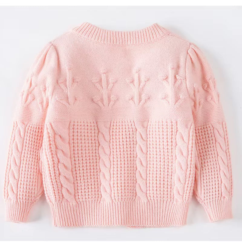 A light pink baby knit sweater with textured cable and leaf patterns, shown from the back on a white background.